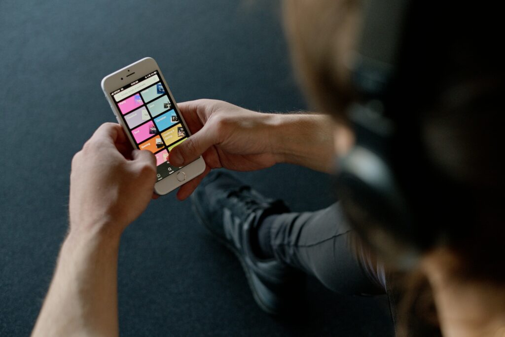 Close-up of a person listening to music on a smartphone while at the gym, focusing on a streaming playlist app.