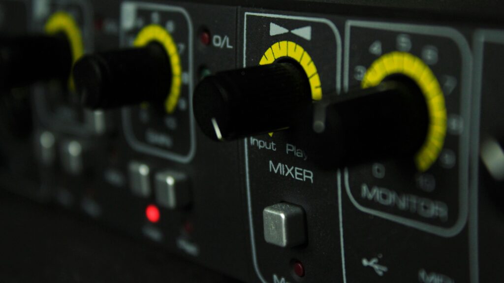 Detailed view of audio mixer control panel with knobs and LED indicators.